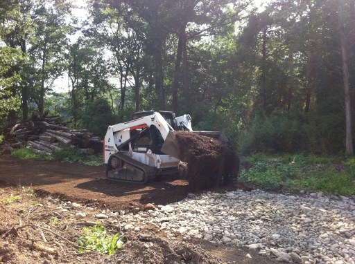Using sand and gravel from the land to lay on top of river stone for a driveway